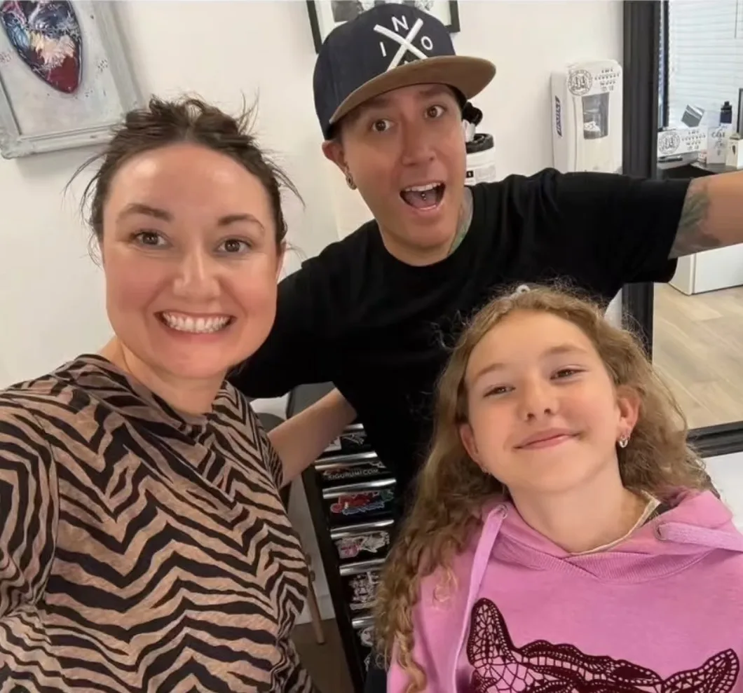 A mom and daughter smiling with Anthony after a piercing appointment