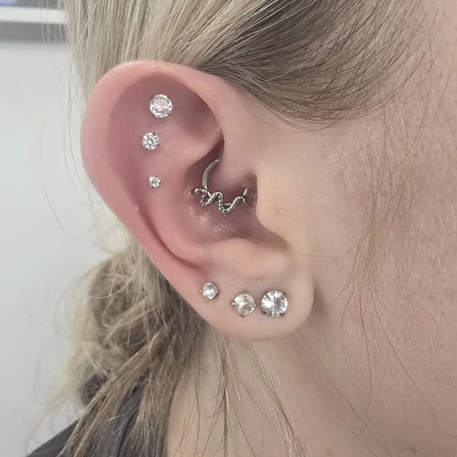 Ear with a sparkle stack, daith and triple lobes